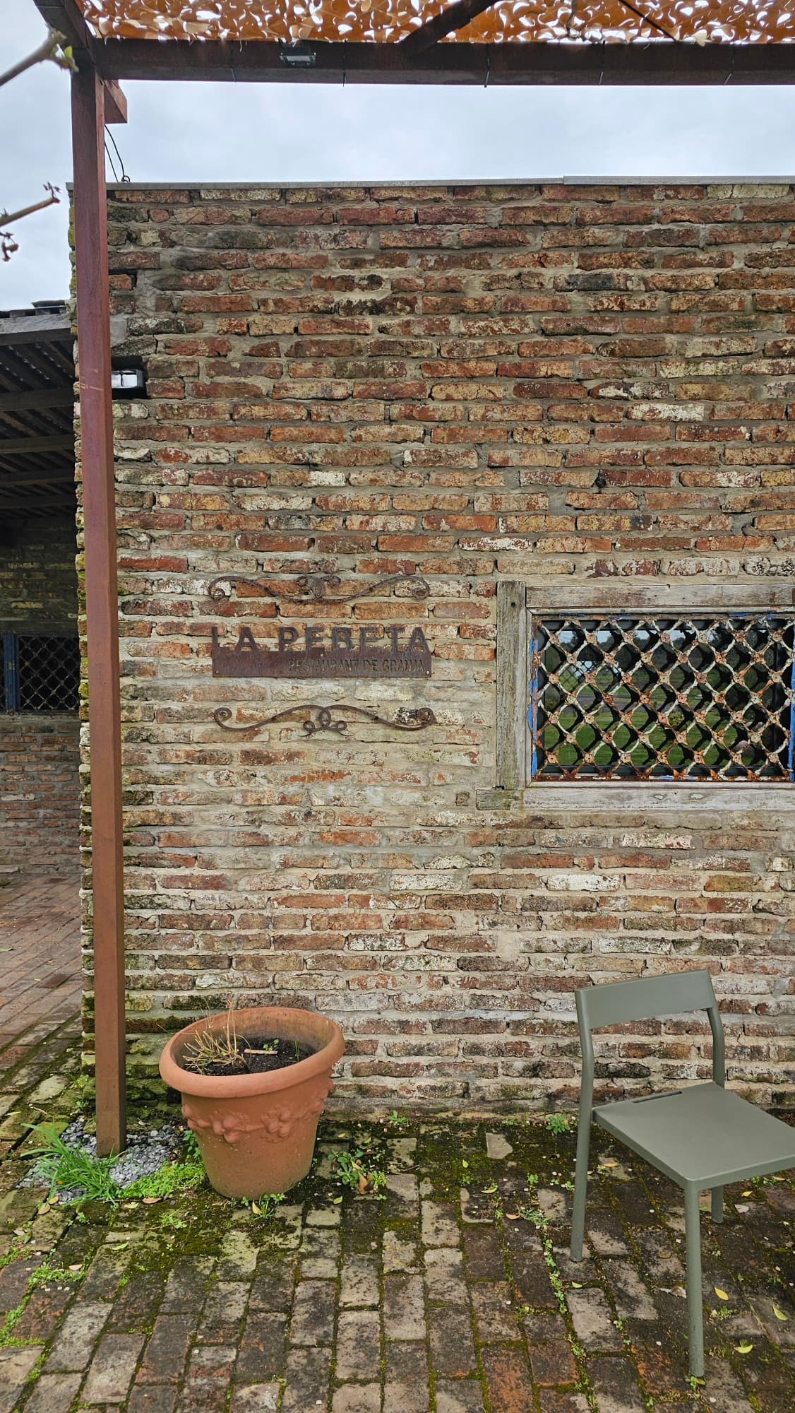 Pared de ladrillo con el cartel de La Pebeta