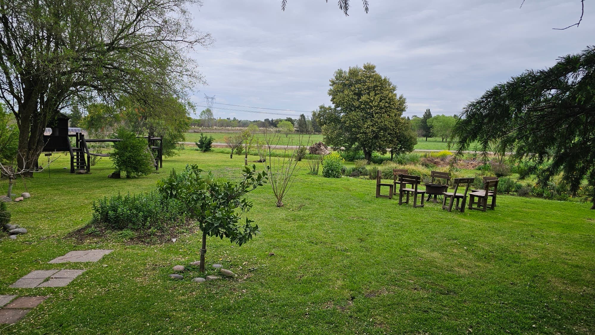 Jardín con mesas y el campo de fondo
